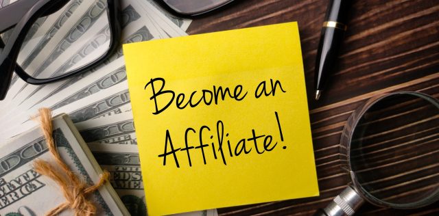 Colored sticky note with the word Become an affiliate on wooden background